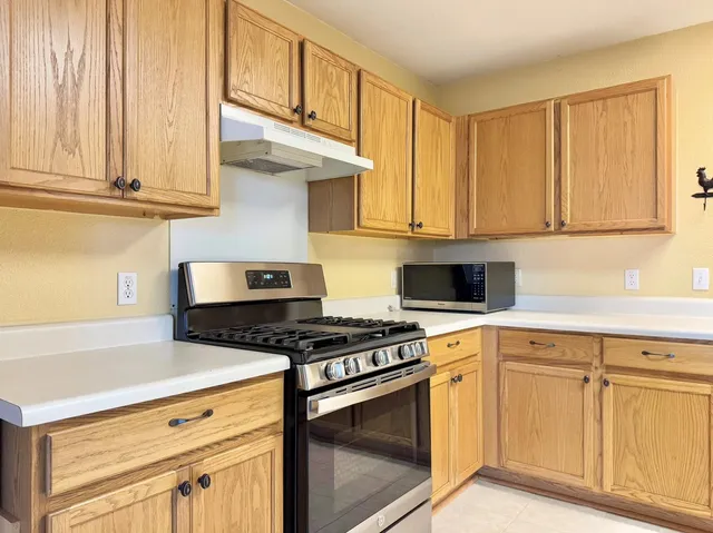 a kitchen with white cabinets and appliances