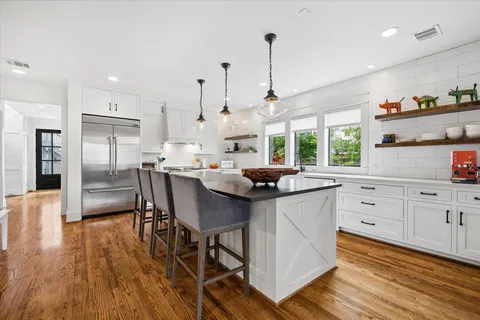a kitchen with stainless steel appliances kitchen island granite countertop a sink table and chairs
