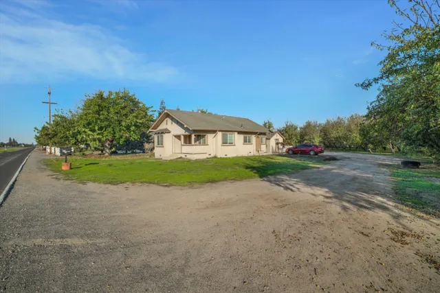 a view of a house with backyard and road