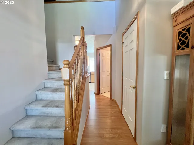 a view of a hallway with wooden floor and entryway