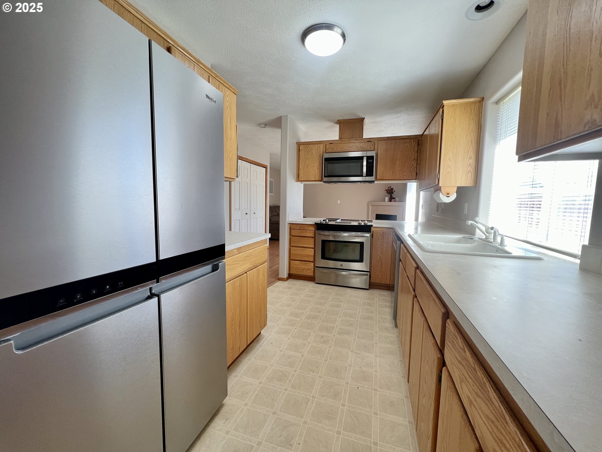 112 Northeast 11th Street Hermiston, OR 97838 - Photo 9 of 23 a kitchen with granite countertop a refrigerator and a sink