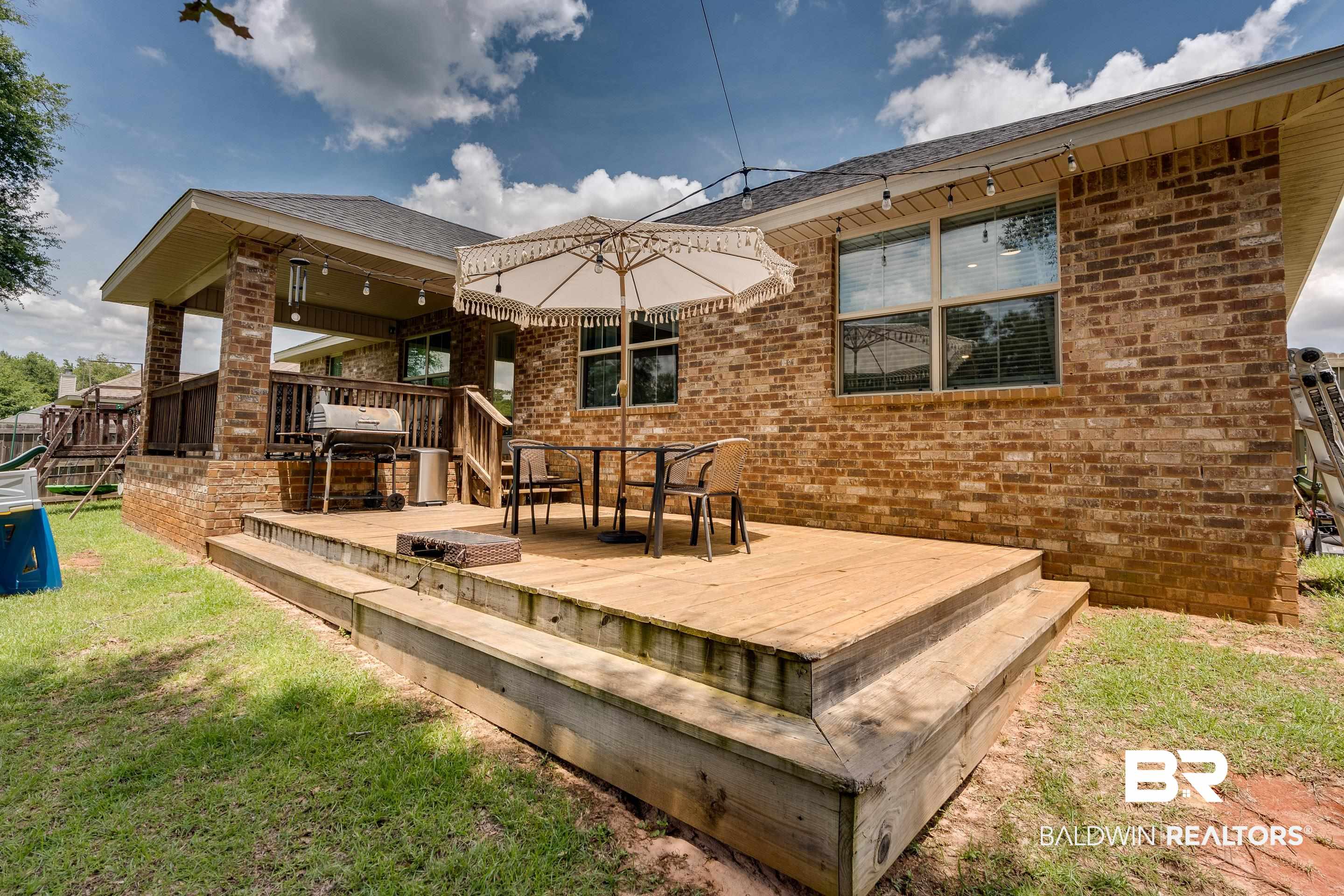 2215 Fernwood Loop West Semmes, AL 36575 - Photo 27 of 40 Expansive wooden deck with multi-level design and direct access to a covered patio