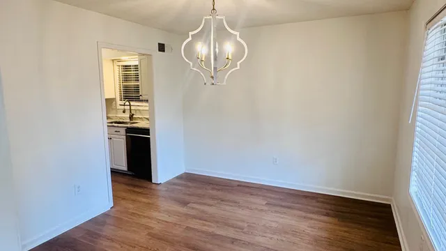 a view of a kitchen with wooden floor and a window