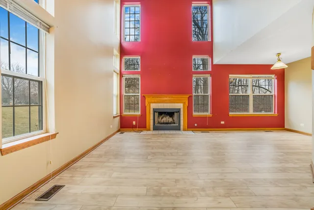 a view of an empty room with window and fire place