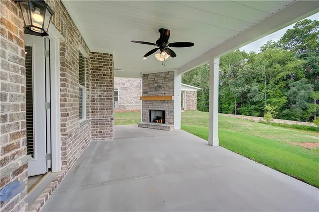 a view of a porch with a fireplace and a yard