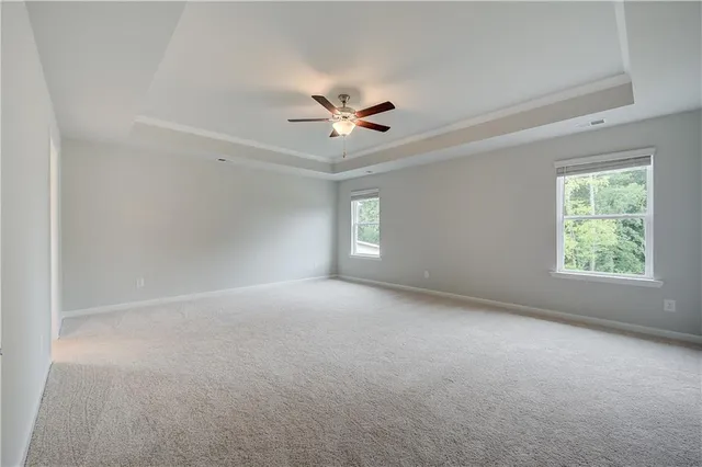 an empty room with windows and ceiling fan