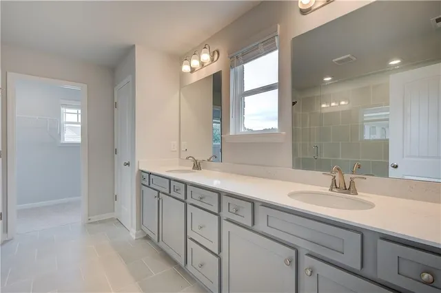a bathroom with double sink and a mirror