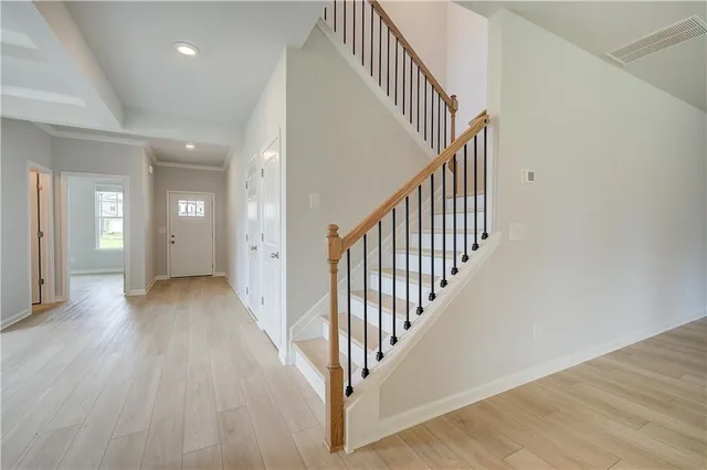 a view of a hallway with wooden floor and entryway