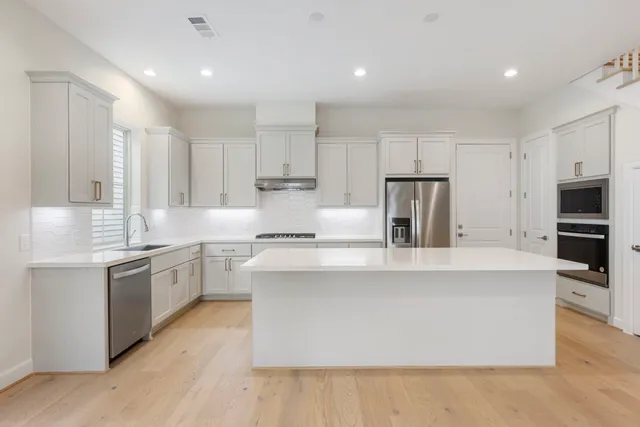 a large kitchen with stainless steel appliances kitchen island a sink a stove a refrigerator and a stove