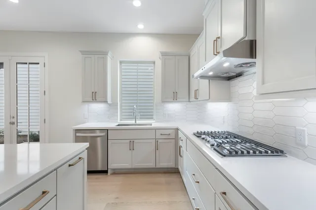 a kitchen with stainless steel appliances a white stove top oven and a refrigerator