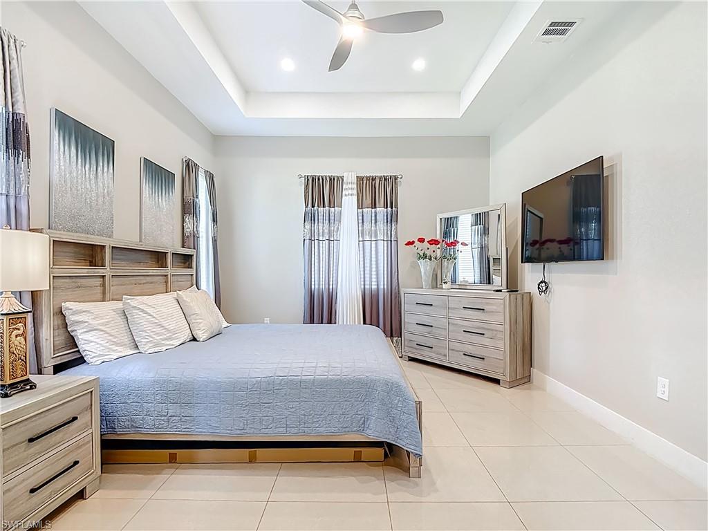 1806 41st Street Southwest Naples, FL 34116 - Photo 10 of 38 a bedroom with a bed and flat screen tv