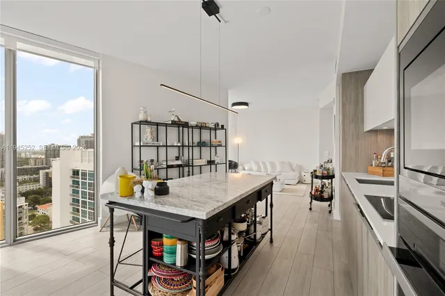 a dining room with furniture a chandelier and wooden floor