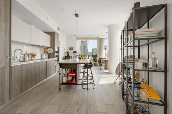 a kitchen with granite countertop a sink appliances cabinets and dining table