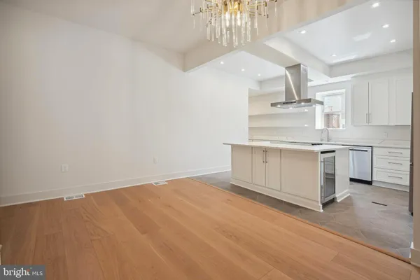 a view of a room with wooden floor and a ceiling fan