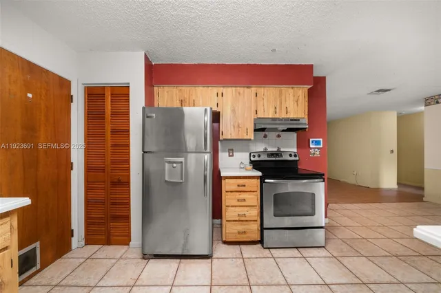 a kitchen with stainless steel appliances granite countertop a refrigerator and a stove
