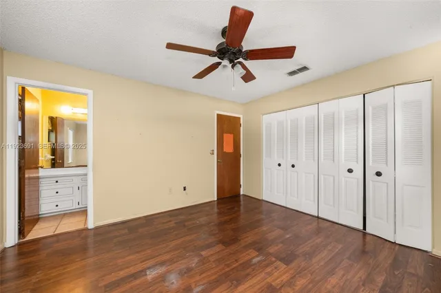 a view of room with wooden floor and ceiling fan