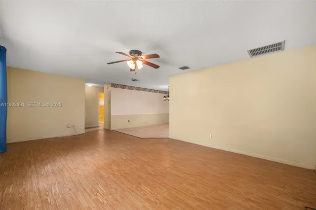 a view of an empty room with wooden floor