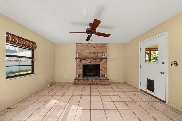 a view of an empty room with a fireplace and a window