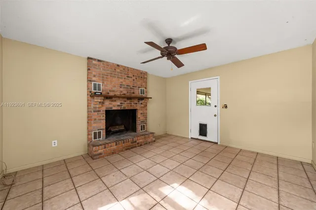 a view of a livingroom with a fireplace and a chandelier fan
