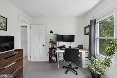 a view of a livingroom with workspace and a window