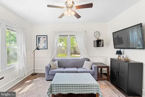 a living room with furniture a flat screen tv and a window