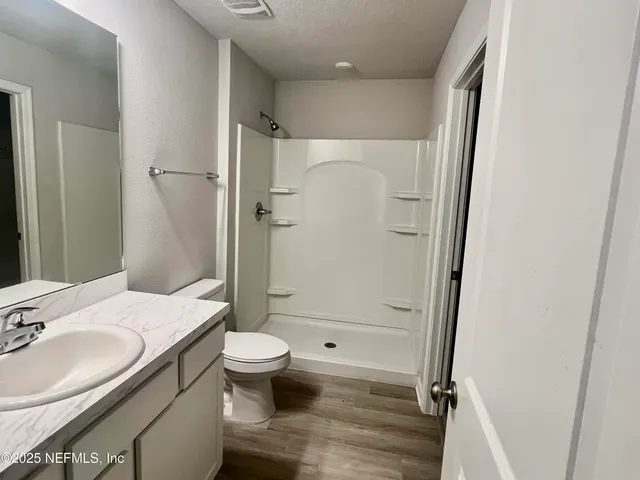 a bathroom with a granite countertop toilet sink and shower