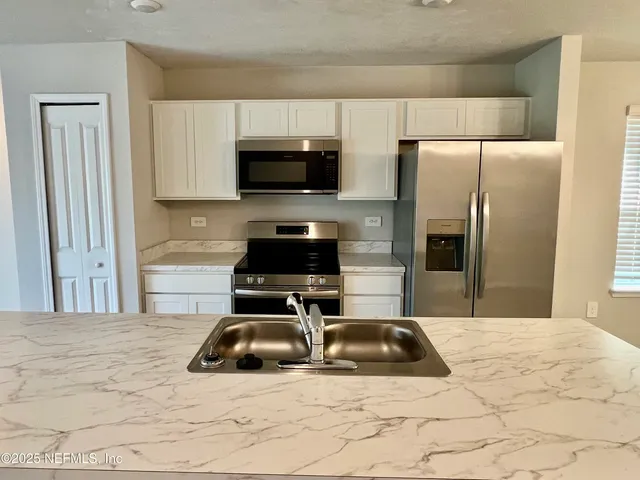 a kitchen with a refrigerator stove and microwave