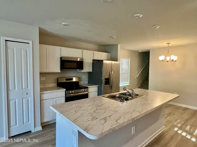 a kitchen with a stove and a wooden floor