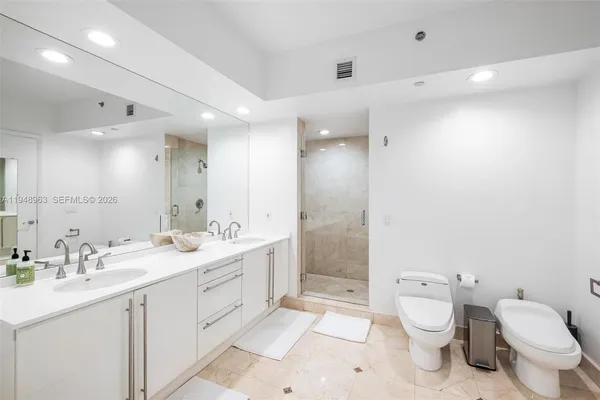 a bathroom with a toilet sink double vanity and mirror