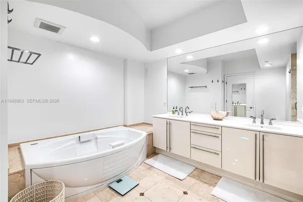a bathroom with a bathtub sink mirror and toilet