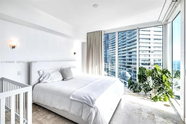 a bedroom with a large bed and a large window
