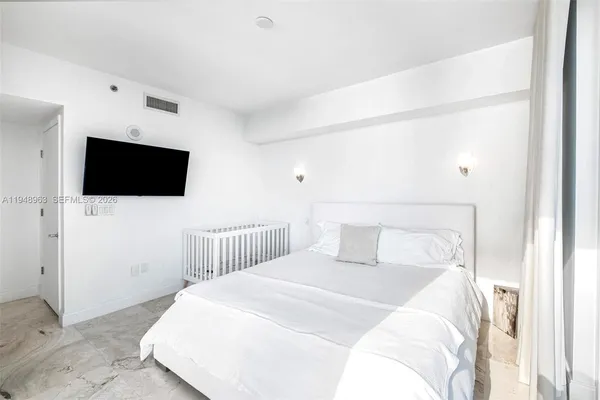 a bedroom with a bed tv and a wall painting