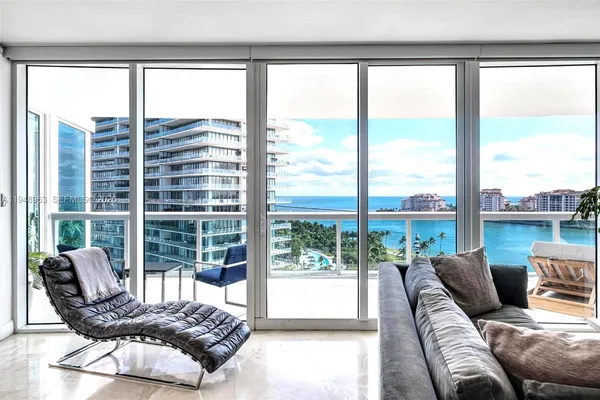 a living room with furniture and floor to ceiling windows