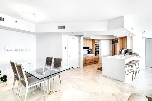 a living room with a couch and a dining table with wooden floor