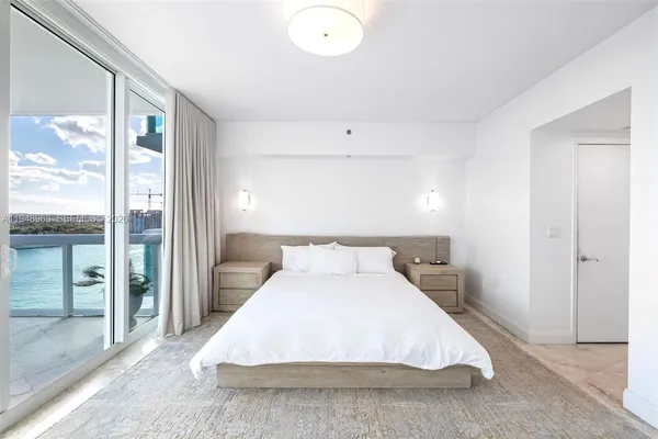 a bedroom with a large bed and a chandelier