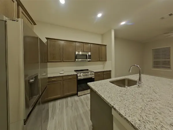 a kitchen with kitchen island a sink appliances and cabinets