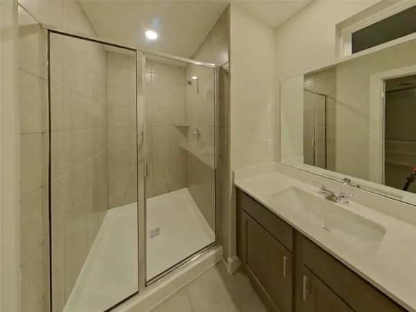 a bathroom with a shower sink and mirror