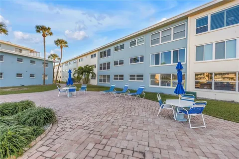 a front view of a building with garden and seating area