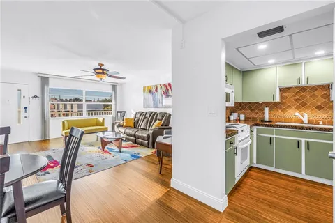a living room with furniture a wooden floor and next to a window