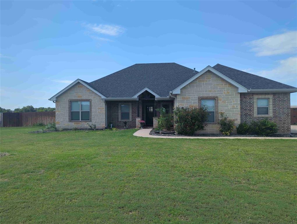 a front view of a house with a garden and yard