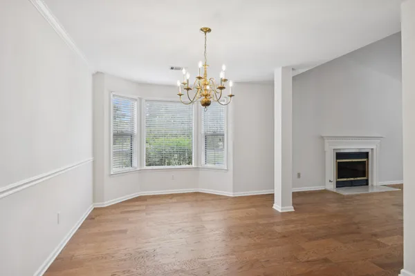 a view of a big room with wooden floor and a chandelier