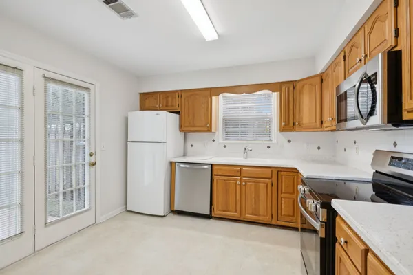 a kitchen with stainless steel appliances granite countertop a refrigerator stove a sink dishwasher and microwave with cabinets