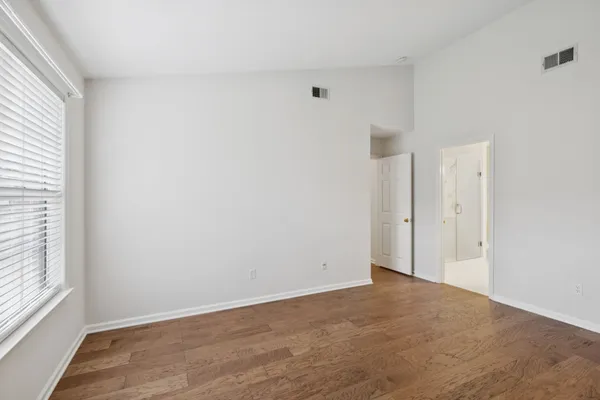 a view of an empty room with wooden floor