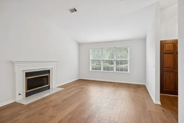 a view of an empty room with a window and a fireplace