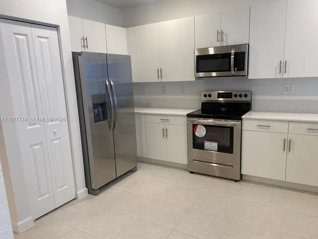 a kitchen with stainless steel appliances a stove microwave and refrigerator