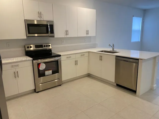 a kitchen with white cabinets and white appliances
