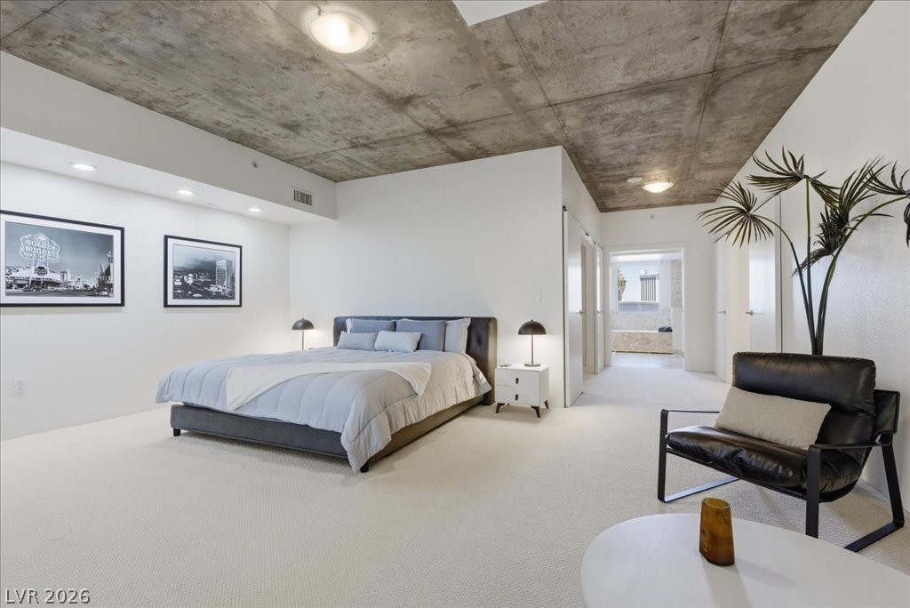 360 East Desert Inn Road, Unit 604 Las Vegas, NV 89109 - Photo 11 of 28 Minimalist comfort meets industrial chic in this naturally illuminated primary bedroom with exposed concrete ceiling.