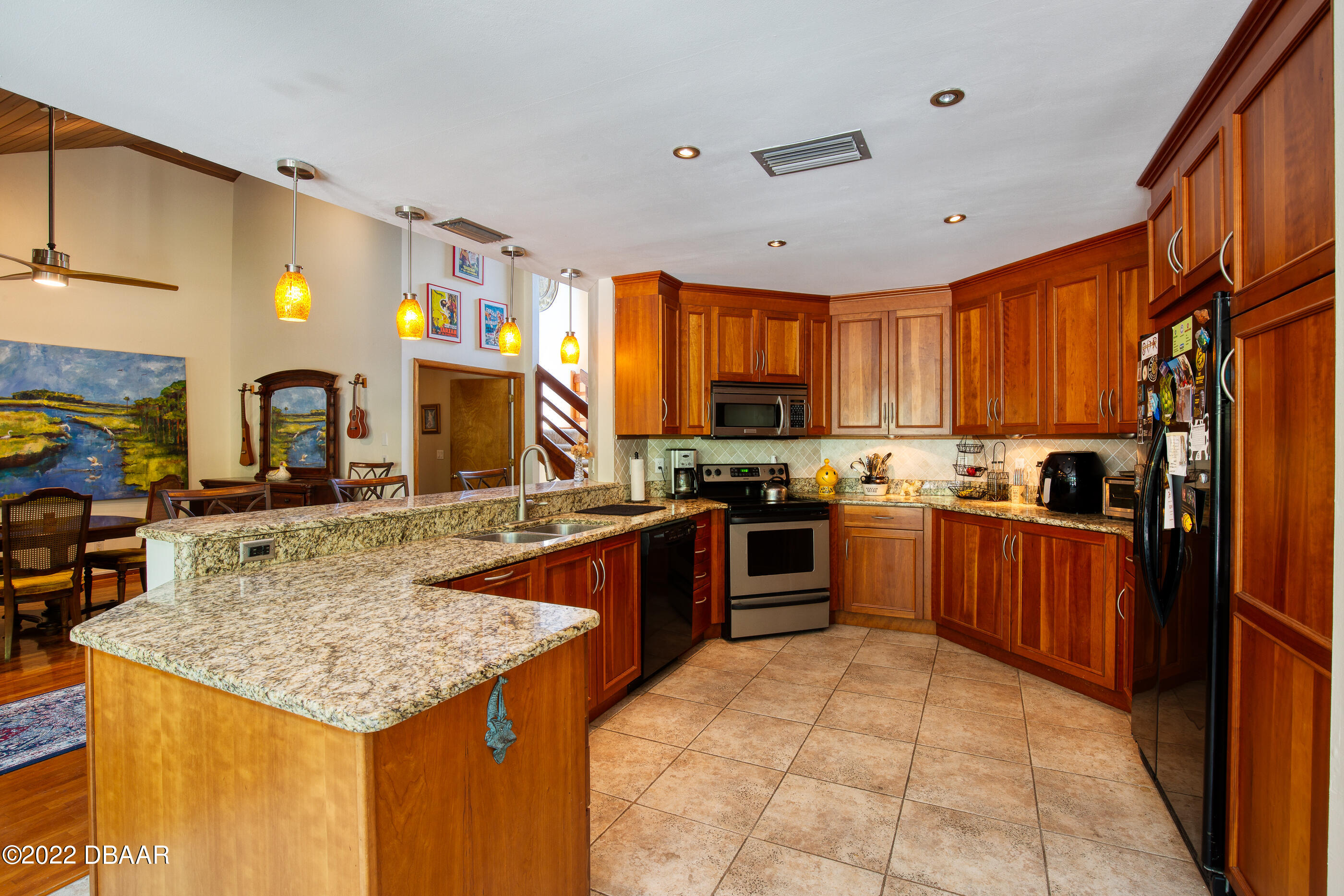 110 River Bluff Drive Ormond Beach, FL 32174 - Photo 21 of 57 a kitchen with stainless steel appliances granite countertop wooden cabinets a stove top oven a sink and dishwasher