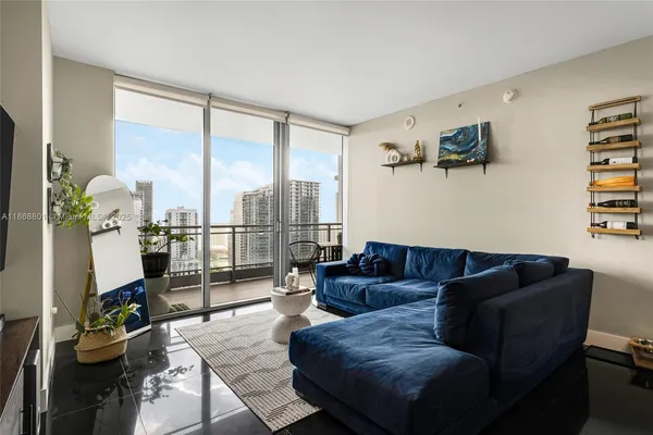 a living room with furniture and a floor to ceiling window