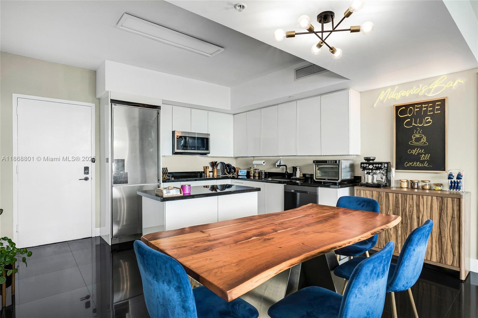 92 Southwest 3rd Street, Unit 4312 Miami, FL 33130 - Photo 4 of 20 a large kitchen with a table chairs refrigerator and cabinets